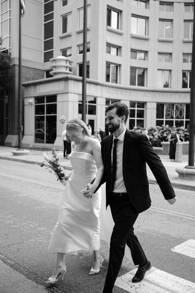 Bride and groom walking out of the St. Charles County Courthouse, smiling after their ceremony — photographed by Jordan Grover Photo documentary photographer.