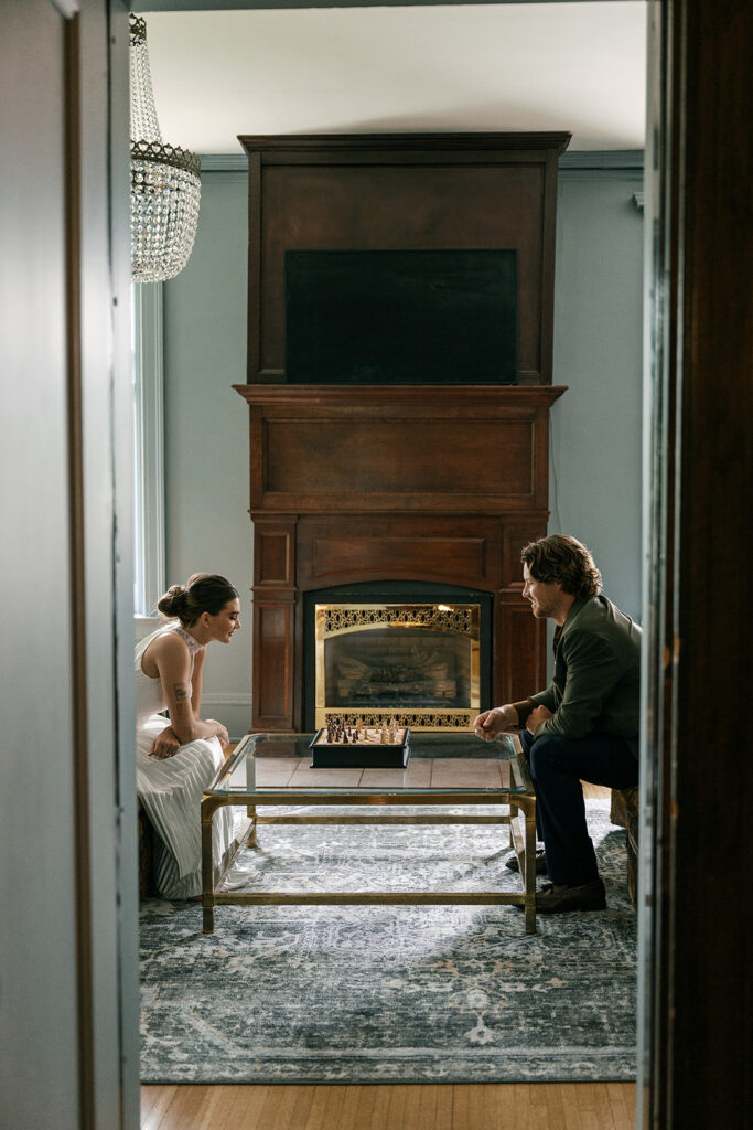 bride and groom playing chess inside historic estate the cotton mansion