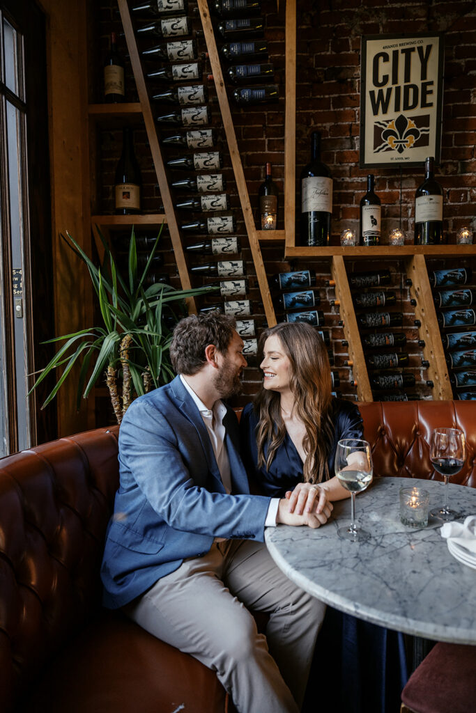 Romantic engagement session at Sasha’s Wine Bar in St. Louis with candid couple laughing together